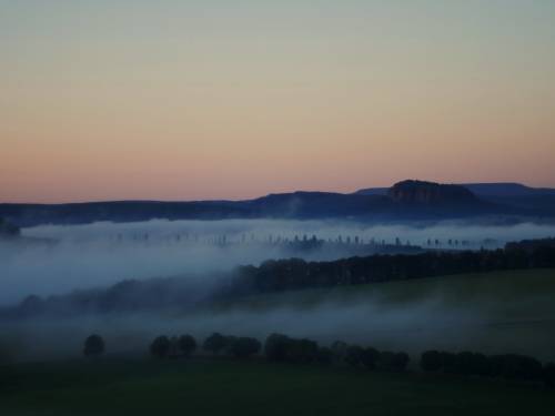 Tafelberg in der sächsische Schweiz im Morgennebel. Im Hintergrund der Hohe Schneeberg.